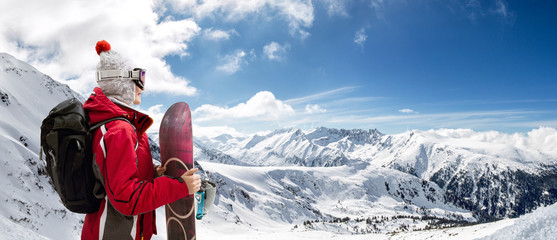 Mädchen steht mit Snowboard