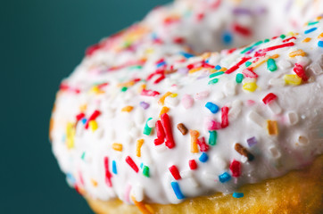 Donut with sprinkles and white iced. Donuts background. Cake and sweet. Food