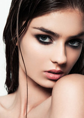 Fototapeta premium Beautiful woman with make up and wet hair on white background