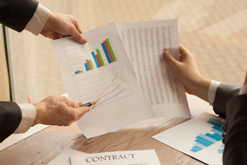 Business person analyzing financial statistics displayed on a sh