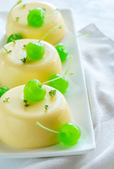 Vanilla puddings decorated with cocktail cherries