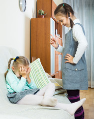 girl lecturing little sister in domestic interior