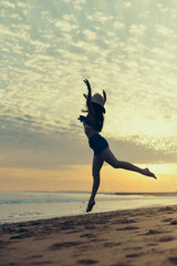 Dance and jump beautiful female silhouette on outdoors background. Dawn sky enjoyment
