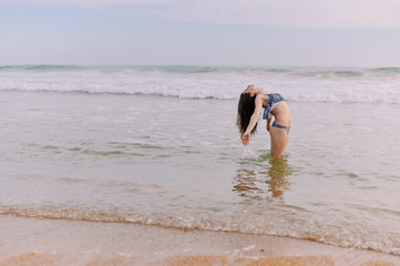 Beautiful female dance in bikini, ocean water background outdoors