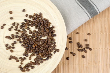 Coffee beans on wooden plate. Top view.