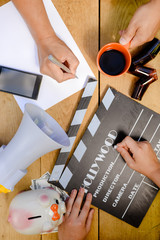 Film production process. Planning to make movie. Clapperboard, megaphone, piggy bank, mobile phone and alarm clock.