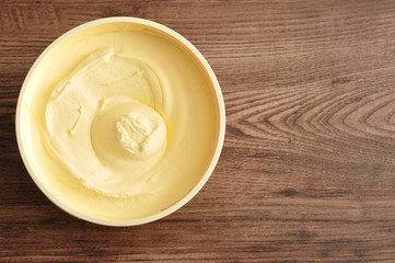 Butter isolated on a wooden background - obrazy, fototapety, plakaty