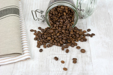 Coffee beans poured from a jar.
