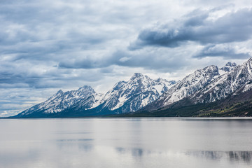 Fototapeta na wymiar Grand Teton mountains with lake and dark, stormy cloudy, overcast, sky in national park