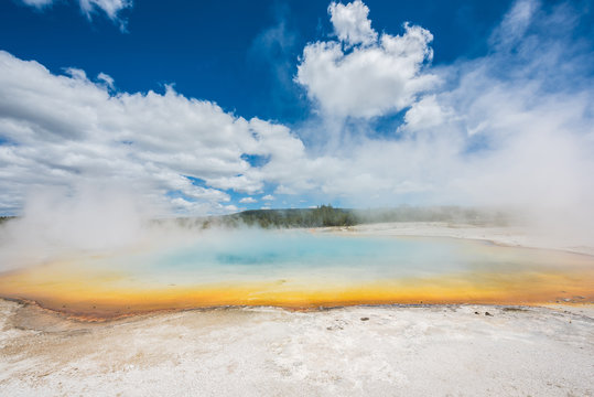 Rainbow pool in Black Sand Basin in Yellowstone National Park with orange and light blue colors with steam rising