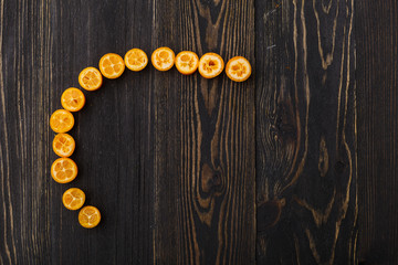 kumquat on a black wooden background