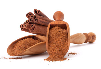 ground cinnamon spice powder in wooden spoon isolated on white b
