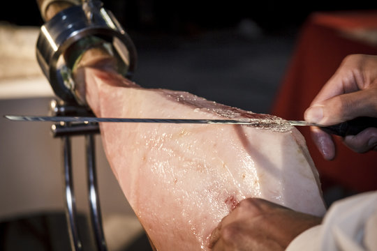 Cortador de jamón cortando un cinco jotas. degustación de jamón ibérico de bellota. Noches gastronómicas de verano.