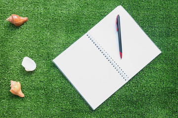 notebook and pen on artificial grass