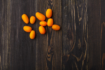 Fototapeta na wymiar kumquat on a black wooden background