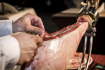 Cortador de jamón cortando un cinco jotas. degustación de jamón ibérico de bellota. Noches gastronómicas de verano.