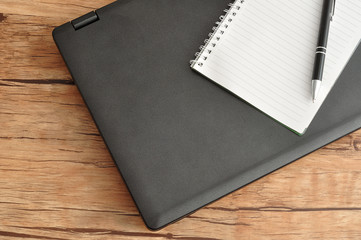 Laptop with a notebook and a pen