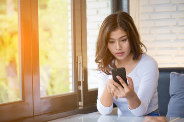 Asian women use smart phone in coffee shop