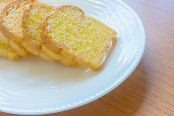 Butter bread in white dish on wooden table