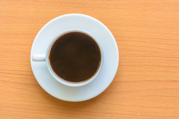 Black coffee in white cup on wooden table