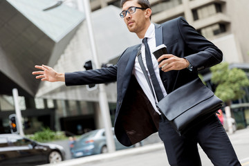 Young businessman hailing for a taxi