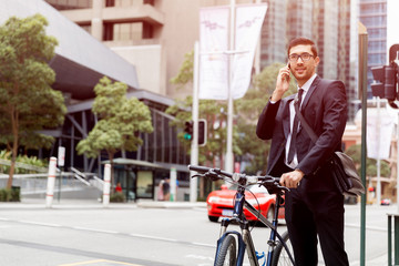 Fototapeta na wymiar Young businessmen with a bike