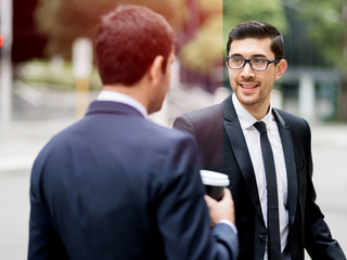 Two businessmen talking outdoors