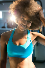 Obraz na płótnie Canvas A young afro american woman standing in a gym