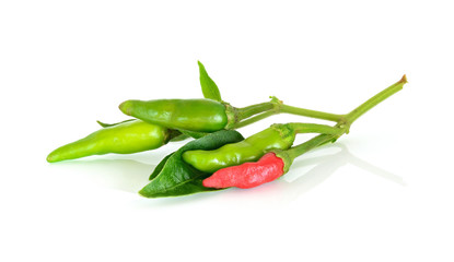 Red and green pepper with leaf on white