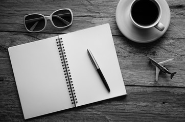 Notebook pen and cup of coffee on wood - tone black and white