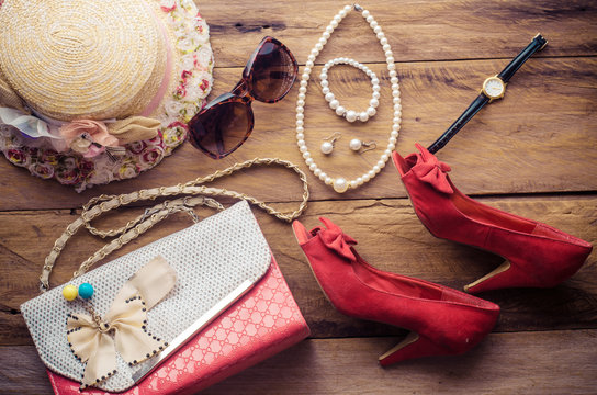 accessories for teenage girl on her vacation, hat, stylish for summer sunglasses, leather bag, shoes and costume on wooden floor.