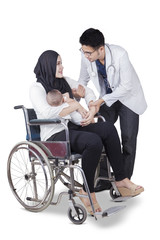 Obraz premium Doctor helping disabled mother