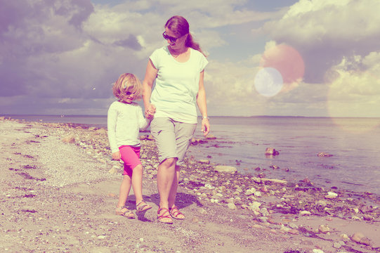 mother and child walking on beach