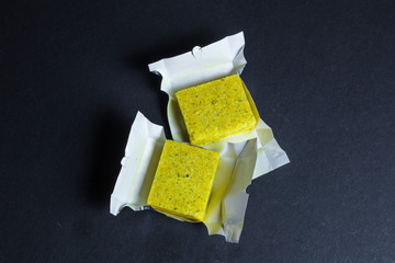 Dehydrated bouillon stock cube salty meat and vegetables aromatic yellow spice, ingredient single whole condiment portion wrapped, open in paper pack