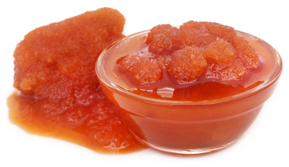 Molasses in a glass bowl over white background