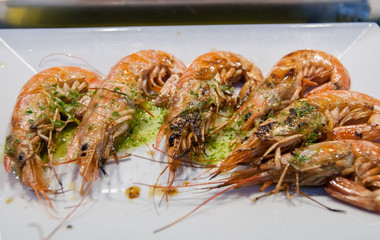 Fried shrimps served on a white plate with garlic