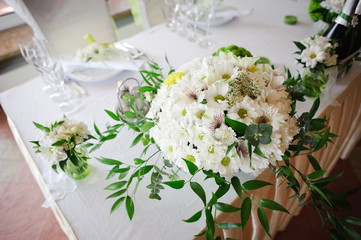 Obraz na płótnie Canvas Wedding table decoration in white and green colors. Wedding floristry. Fresh mix