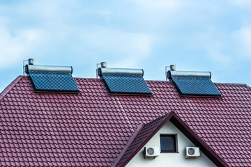 Vacuum collectors- solar water heating system on red roof