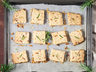 Cookies with rosemary and pine nuts on parchment. Flat lay