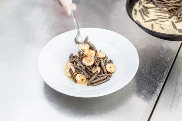 Shrimps served with black pasta