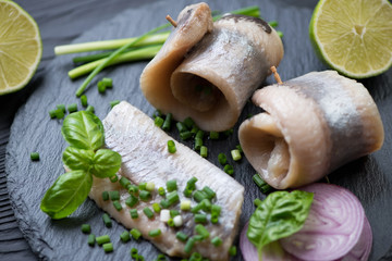 Closeup of herring fillet on a stone slate tray, selective focus