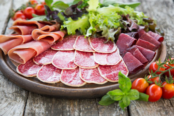 Antipasto with ham, salami and bresaola. tomato and basil. selec