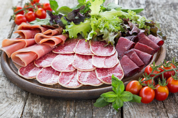 Antipasto with ham, salami and bresaola. tomato and basil. selec