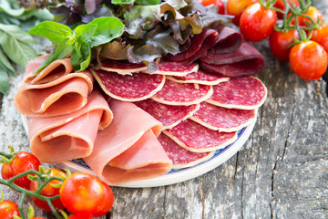 Antipasto with ham, salami and bresaola. tomato and basil. selec