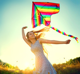 Beauty girl in short dress running with kite on the field