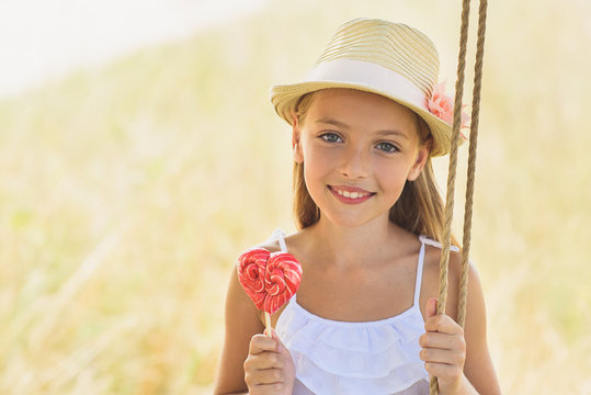 Cheerful kid riding on swing in nature