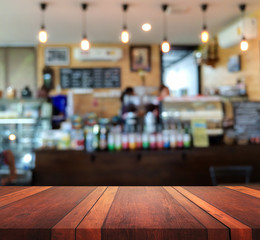 Empty brown wooden table surface and Coffee shop interior blur background with bokeh image, for product display montage,can be used for montage or display your products.