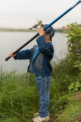 child on a summer fishing on the shore