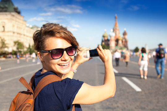 Young attractive woman traveler with backpack on the background