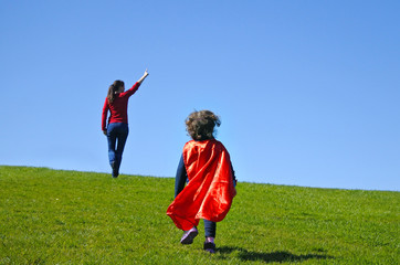 Superhero mother show her daughter how to be  a superhero